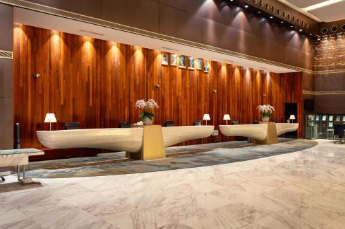 a lobby with two tables with flowers on them at Lexis Hibiscus Port Dickson in Port Dickson