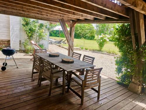 a wooden table and chairs on a wooden deck at La Canolière - Chambre d'hôtes Camille in Sauveterre-Saint-Denis
