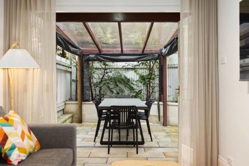 a conservatory with a table and chairs on a patio at Holiday Home with Outdoor Area for 8 Guests in Sydney