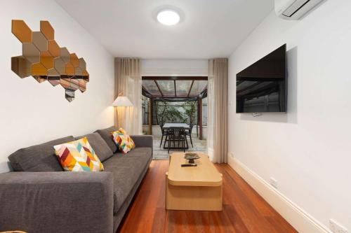a living room with a couch and a table at Holiday Home with Outdoor Area for 8 Guests in Sydney