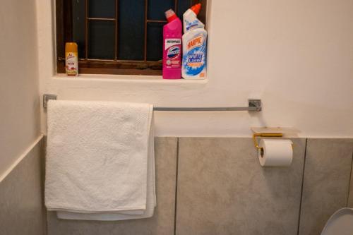 a bathroom with a window and towels on a shelf at Optimum Stay Self Catering Accommodation - Deluxe Room in Cape Town