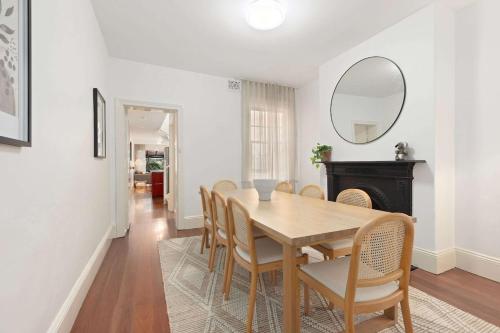 a dining room with a table and chairs and a mirror at Holiday Home with Outdoor Area for 8 Guests in Sydney