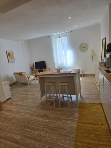 une cuisine avec une table et des tabourets dans une pièce dans l'établissement Moderne et lumineux provençal, à Belgentier