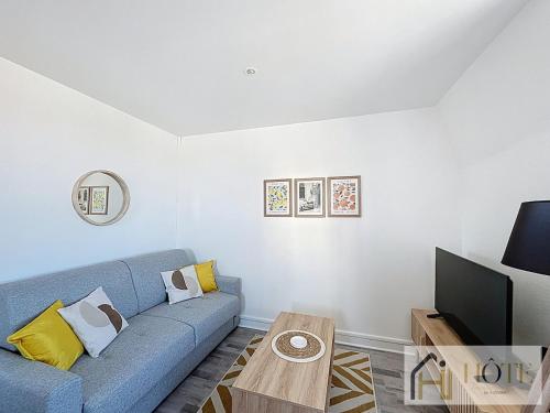 un salon avec un canapé bleu et une table dans l'établissement L'Appartement du Centre 1CH, à Dunkerque