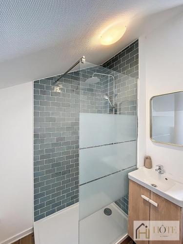 une salle de bain avec une douche en verre et un lavabo dans l'établissement L'Appartement du Centre 1CH, à Dunkerque