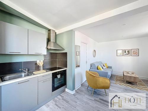 une cuisine avec un évier et un canapé dans une chambre dans l'établissement L'Appartement du Centre 1CH, à Dunkerque