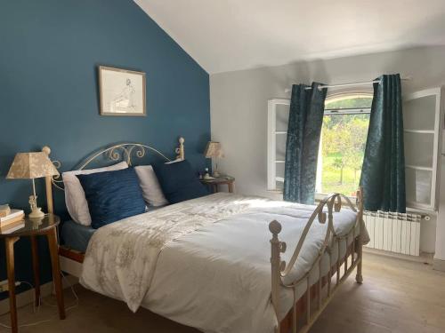une chambre avec un lit aux murs bleus et une fenêtre dans l'établissement Sublime villa climatisée Arles, à Arles