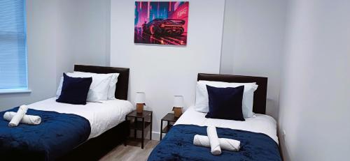 a bedroom with two beds with pillows at Spacious 4 Bedroom House-2 bathrooms-Contractor-Family-Relocation-Professionals-Parking-Close-to-All-Amenities in Luton