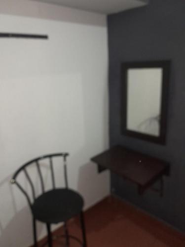 une chambre avec une chaise, un miroir et une table dans l'établissement Wayanad Wildlife Sactuary Bamboo Groves, à Jāmb