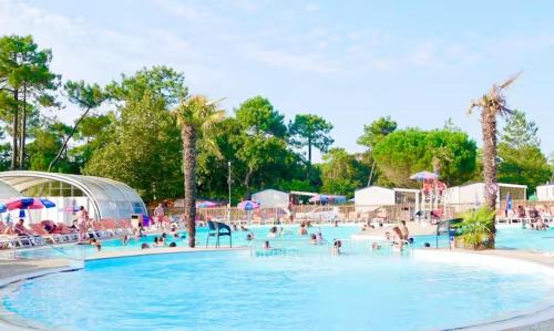 un groupe de personnes dans une piscine d'un complexe hôtelier dans l'établissement Au Ferret plage,piscines à 2 pas en famille by Vayny, à Lège-Cap-Ferret