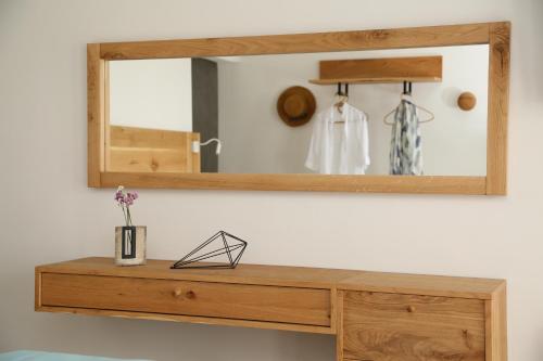 a wooden dresser with a mirror on a wall at Villa Camelia 2 - Psarou View - Private pool and Jacuzzi in Mýkonos City