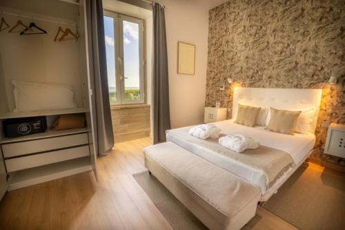 a bedroom with a bed with towels on it at Hotel Solar Palmeiras in Paço de Arcos