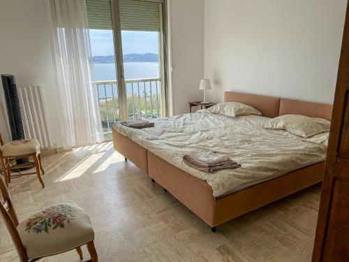 une chambre avec un lit et une grande fenêtre dans l'établissement Le Goéland, à Toulon