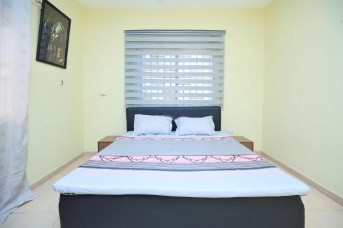 a bedroom with a large bed in a room at Groove Lodge in Tema