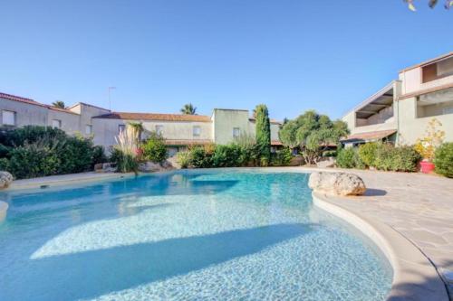 une grande piscine bleue dans une cour dans l'établissement Lyo pavillon, à Valras-Plage
