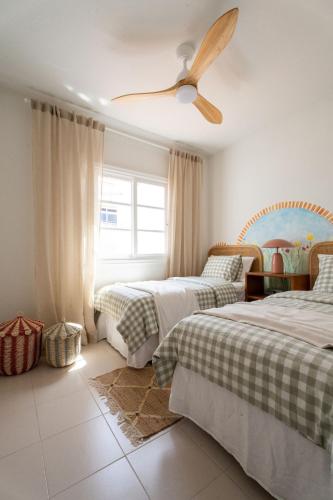 a bedroom with two beds and a ceiling fan at Mosaico Ocean View Boutique Apartment in Adeje
