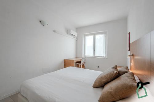 a white bedroom with a bed with pillows on it at HOTIDAY Apartment Collection - Portoferraio in Portoferraio