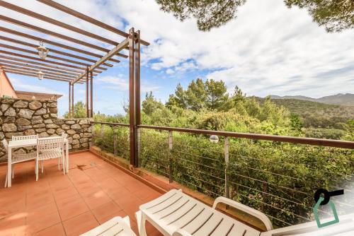 a patio with white furniture and a view of the mountains at HOTIDAY Apartment Collection - Portoferraio in Portoferraio