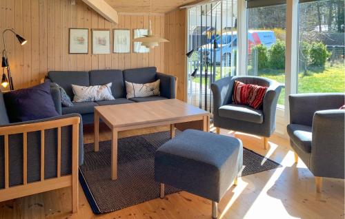 ein Wohnzimmer mit einer Couch und einem Tisch und Stühlen in der Unterkunft Three-Bedroom Holiday Home In Ebeltoft in Ebeltoft