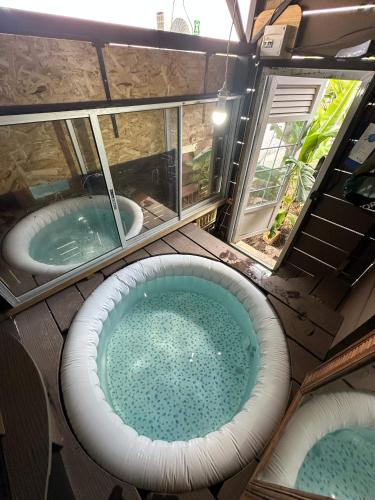 two hot tubs in a room with two windows at Kozy Kaz - Les pieds dans l eau in La Trinité