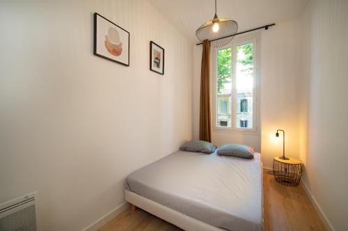 une petite chambre avec un lit et une fenêtre dans l'établissement Appartement climatisé 2 chambres avec parking à 10min à pieds de la Gare St Charles, à Marseille