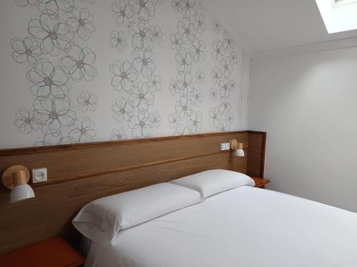 a bedroom with a bed and a wall with flowers at Pensión O Escondidino in Baiona