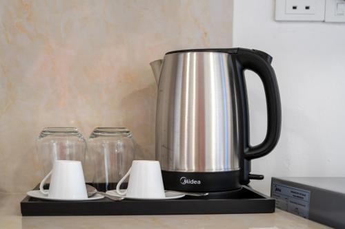 a coffee pot sitting on top of a stove at Pearls Apartments in Ukulhas