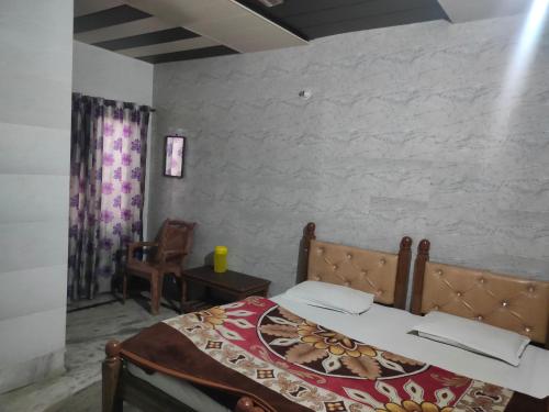 a bedroom with a bed and a chair in it at Singh Hotel's Shubhadra Boutique Stay in Mathura