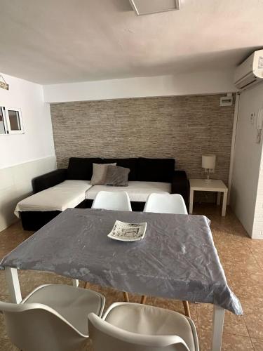 a living room with a table with chairs and a couch at Apartamento Barbacoa, Piscina y playa in Puebla de Farnals