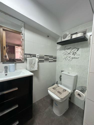 a bathroom with a toilet and a sink at Apartamento Barbacoa, Piscina y playa in Puebla de Farnals