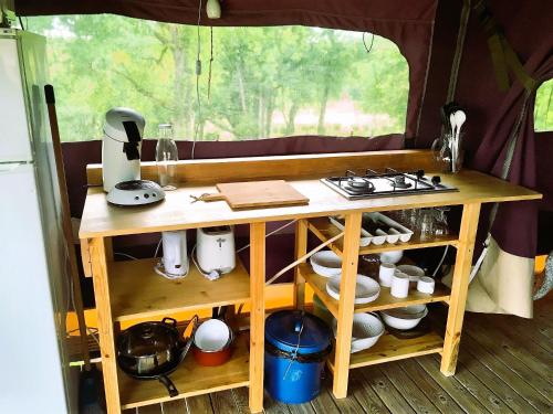a table in a tent with a stove and dishes at Auberge Casa Sana in Pillac