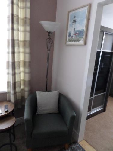 a living room with a chair and a lamp at Nathans in Blackpool