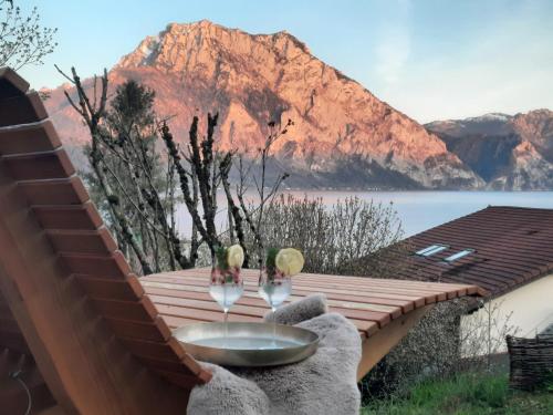 a table on a deck with a view of a mountain at Gallery - Terrasse mit Seeblick und Garten in Altmünster