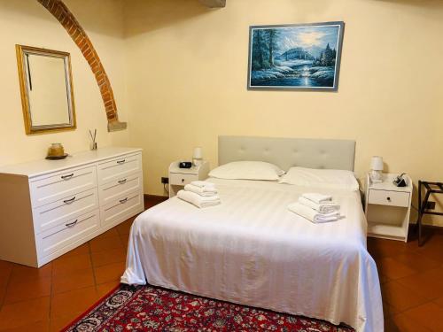 a bedroom with a white bed and a mirror at Villa Schiatti in Cortona