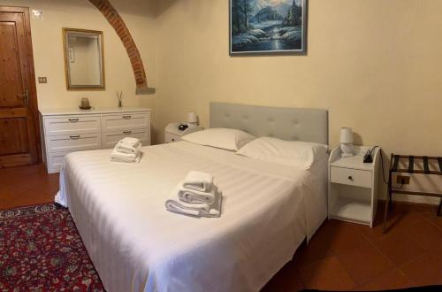 a bedroom with a large white bed with towels on it at Villa Schiatti in Cortona