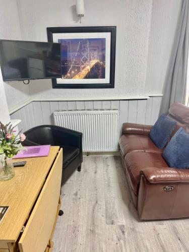 a living room with a couch and a tv at The Victorian lodge in Ryde