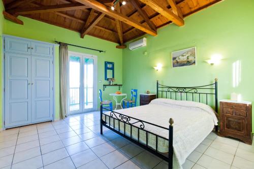 a bedroom with a bed in a room with green walls at Aretousa Studios & Apartments in Skopelos Town