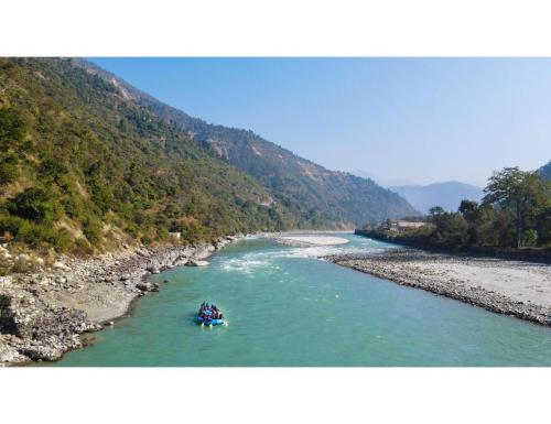 a group of people on a raft in a river at Alaknanda Adventure Resort and Rafting Camp in Nandaprayāg