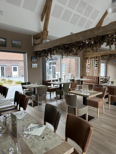 une salle à manger avec tables, chaises et fenêtres dans l'établissement La Maison de nos Parents, à Gonnehem