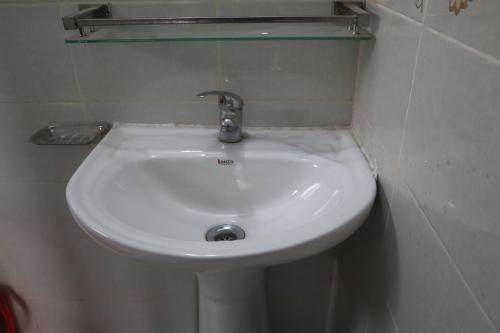 a white sink in a bathroom with a mirror at Dwelling Furnished Flat in Faydābād