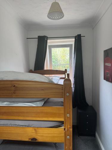 a bedroom with a wooden bed and a window at The Victorian lodge in Ryde