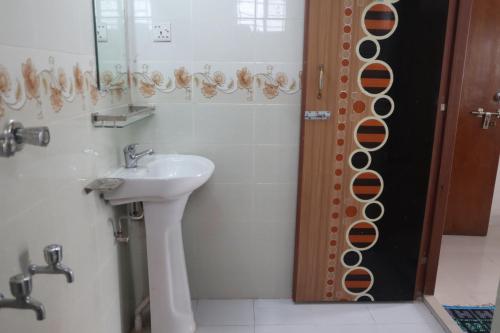 a bathroom with a sink and a shower with a mirror at Dwelling Furnished Flat in Faydābād