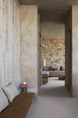a bedroom with two beds and a stone wall at Perma Serifos in Serifos Chora