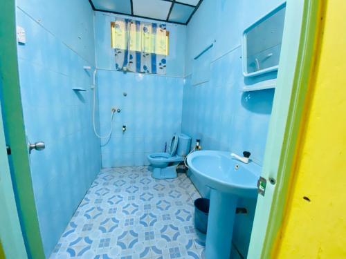 NikawatawanaChinna cottage的浴室设有蓝色的卫生间和水槽。