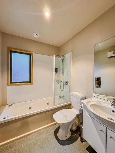 a bathroom with a shower and a toilet and a sink at Bealey Avenue Motel in Christchurch