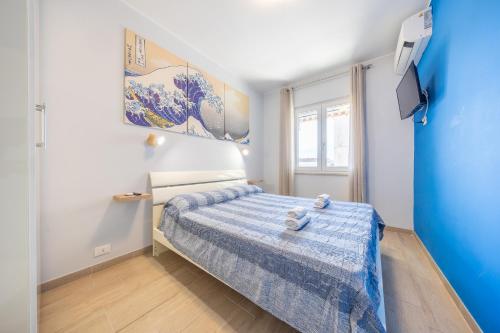 a small bedroom with a bed with a blue comforter at “la casetta al mare” in Anzio
