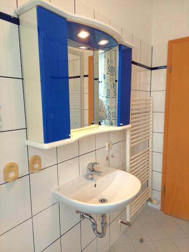 a bathroom with a white sink and a blue cabinet at Villa Hoffnung in Bad Elster
