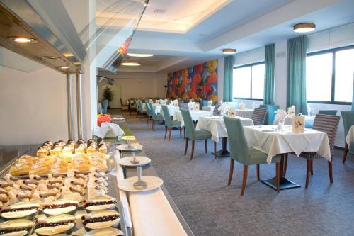 a restaurant with tables and chairs and food on display at Mediterranean Beach Resort in Laganas