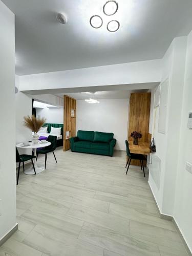 a living room with a green couch and a table at Luxury Studios at Unique opposite Palas with Parking in Iaşi