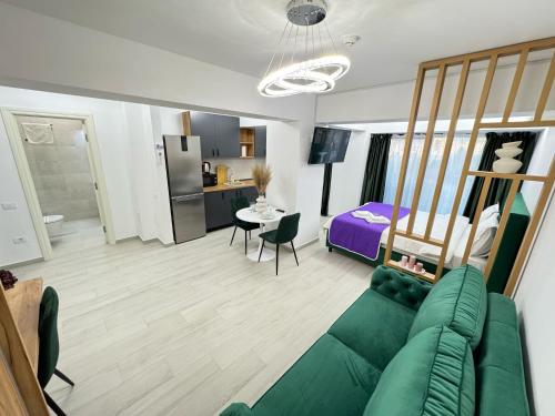 a living room with a green couch and a bed at Luxury Studios at Unique opposite Palas with Parking in Iaşi